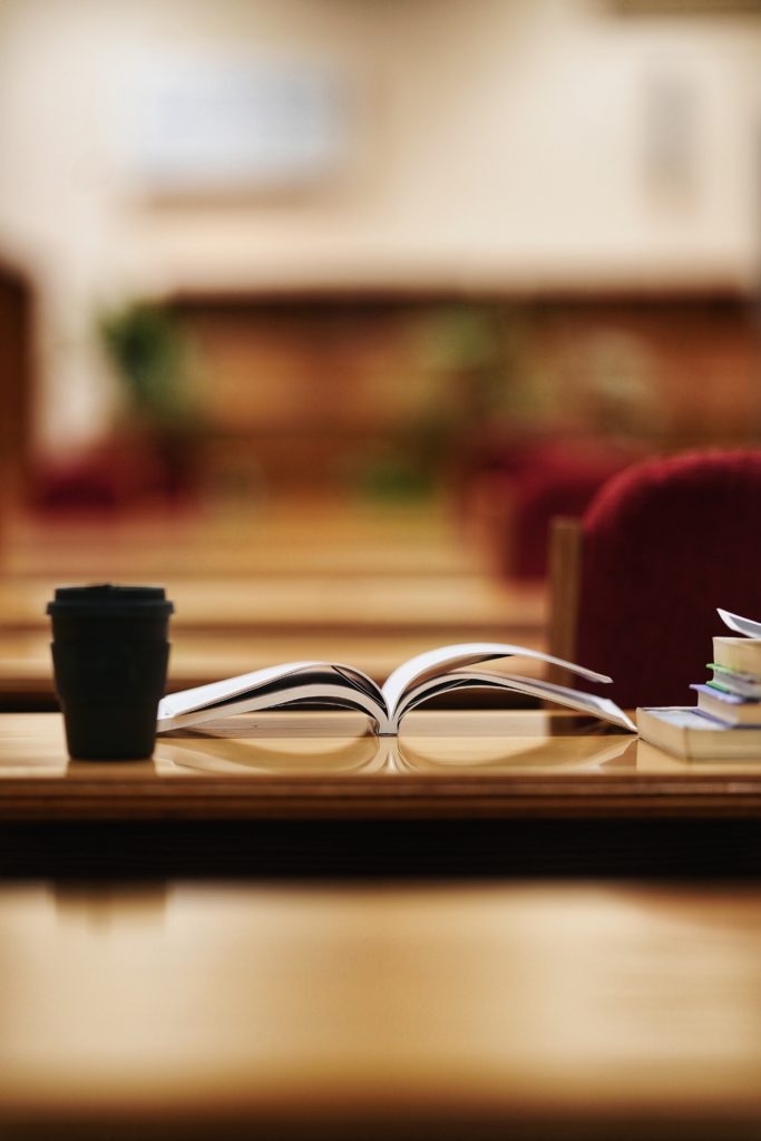 Books and a coffee cup on a table.